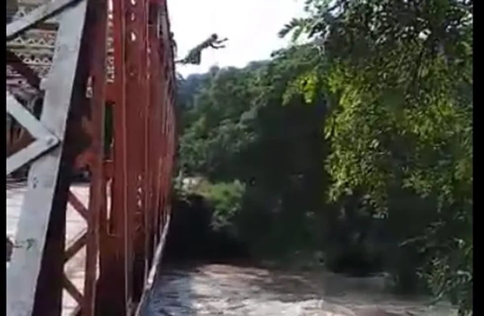 Video: adolescentes saltan desde un puente de hierro en plena crecida del río Loro. (Captura)