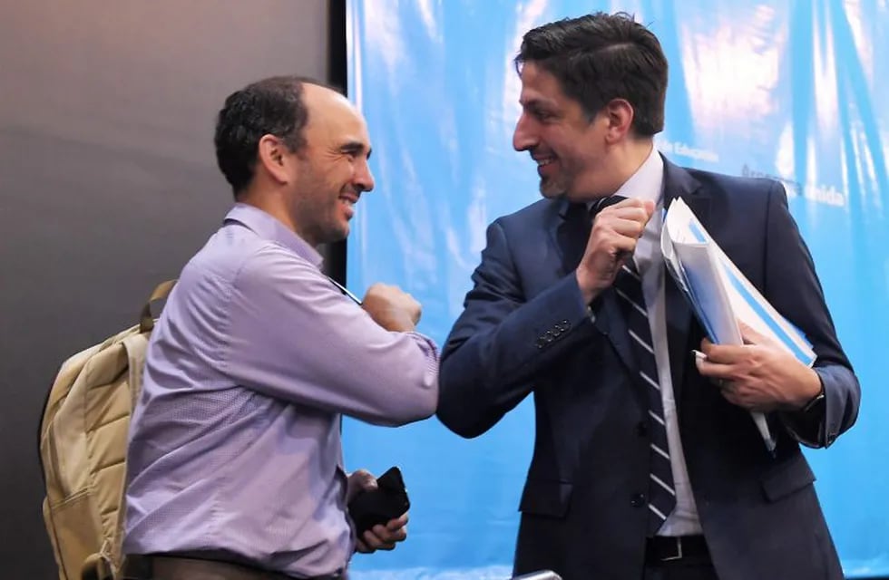 13 March 2020, Argentina, Buenos Aires: Nicolas Trotta (R), Argentina's education minister, taps elbows with a colleague before a press conference on school and university activities in the context of the coronavirus prevention measures. Photo: Victor Carreira/telam/dpa