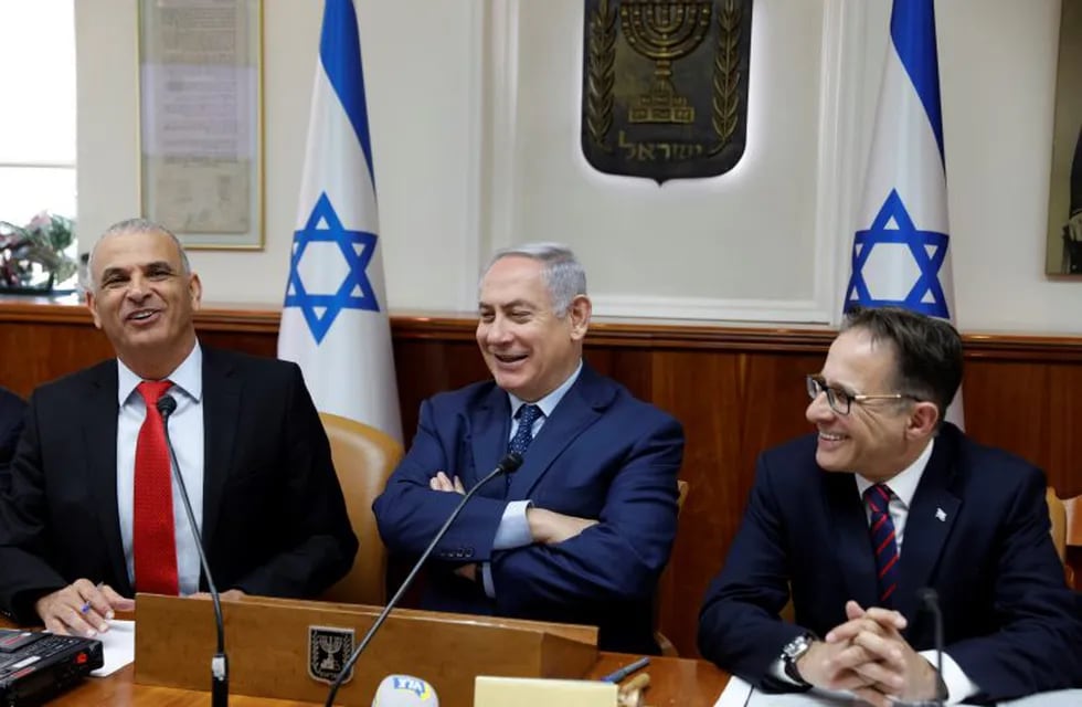 Israeli Prime Minister Benjamin Netanyahu, center, sits between Government secretary Braverman Tzachi, right, and Finance Minister Moshe Kahlon, at the start of the weekly cabinet meeting at the Prime Minister's office in Jerusalem, Sunday, April 15, 2018. (Gali Tibbon/Pool via AP)