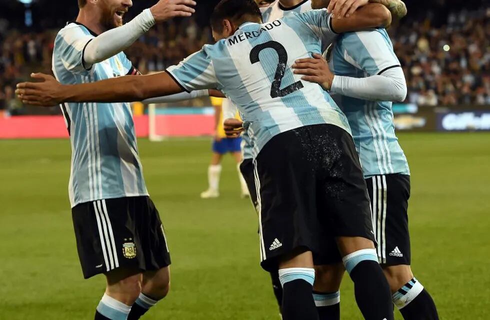 Argentina's forward Lionel Messi (L) celebrates with teammate Gabriel Mercado (C) for his first goal during their friendly international football match between Brazil and Argentina at the MCG in Melbourne on June 9, 2017. / AFP PHOTO / SAEED KHAN / IMAGE RESTRICTED TO EDITORIAL USE - STRICTLY NO COMMERCIAL USE