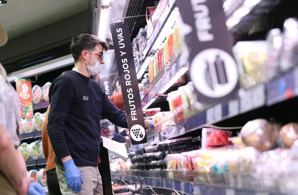 GRAF976. MADRID, 24/03/2020.- Varias personas hacen la compra con mascarilla y guantes en un supermercado en Madrid este martes durante la segunda semana de aislamiento decretado para frenar el avance del coronavirus. EFE/Rodrigo Jiménez