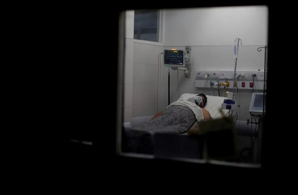 A patient infected with COVID-19 lies on a bed at a hospital in Mar del Plata, Argentina, Saturday, Oct. 10, 2020. Mar del Plata residents, the most popular beach destination in the country, face an uncertain summer season while health authorities warn about the situation of Covid-19 cases increasing in the region. (AP Photo/Natacha Pisarenko)
