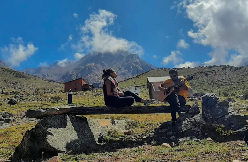 Irina cantando con postales de montañas de Mendoza.
