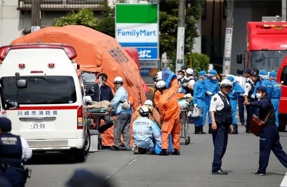 Rescuers work at the scene of an attack in Kawasaki, near Tokyo Tuesday, May 28, 2019. A man wielding a knife attacked commuters waiting at a bus stop just outside Tokyo during Tuesday morning's rush hour,  Japanese authorities and media said. (Kyodo News via AP)