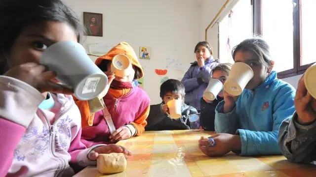 Una taza bien caliente. Los chicos de la villa Hermana Sierra esperan ansiosos la merienda de las 5 de la tarde. Los criollitos “vuelan” y todos celebran la chocolatada (Antonio Carrizo / La Voz).