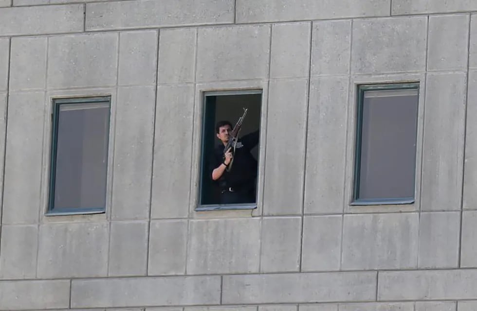 An Iranian policeman holds a weapon as he stands by a window at the Iranian parliament in the capital Tehran on June 7, 2017 during an attack on the complex. \nThe Islamic State group claimed its first attacks in Iran as gunmen and suicide bombers killed at least five people in twin assaults on parliament and the tomb of the country's revolutionary founder in Tehran. / AFP PHOTO / FARS NEWS / OMID VAHABZADEH