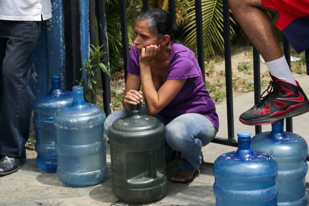 La gente aguarda para recargar agua potable (AFP)