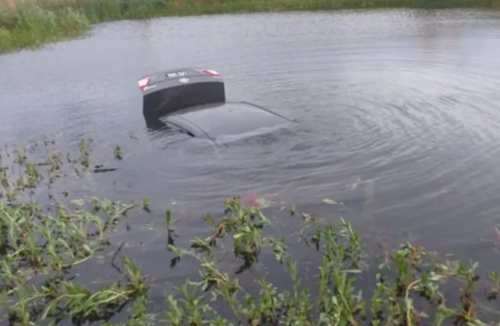 Un automóvil quedó dentro de una laguna artificial.