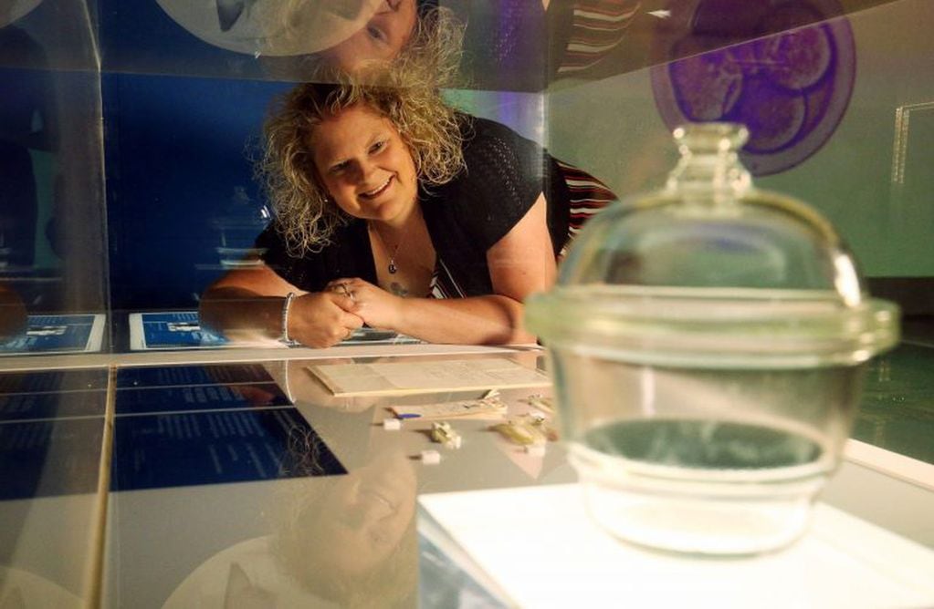 Louise Brown, la primera persona nacida por fecundación in vitro, sonríe junto a los instrumentos que se utilizaron para que ella naciera en Londres, Reino Unido. Crédito: Jonathan Brady/PA Wire/dpa.