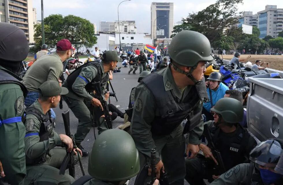 Members of the Bolivarian National Guard loyal to Venezuelan opposition leader and self-proclaimed acting president Juan Guaido take position in front of La Carlota base in Caracas on April 29, 2019. - Venezuelan opposition leader and self-proclaimed acting president Juan Guaido said on Tuesday that troops had joined his campaign to oust President Nicolas Maduro as the government vowed to put down what it called an attempted coup. (Photo by Yuri CORTEZ / AFP)