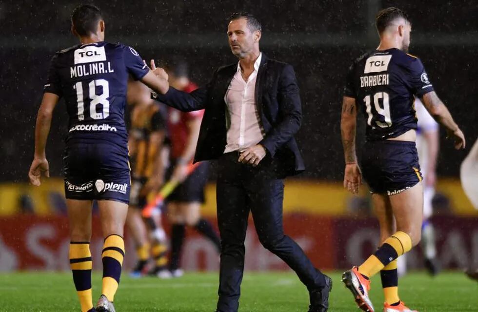 Diego Cocca, coach of Argentina's Rosario Central, greets his player Nahuel Molina at the end of a Copa Libertadores Group H soccer match against Chile's Universidad Catolica in Rosario, Argentina, Wednesday, April 24, 2019. (AP Photo/Gustavo Garello)