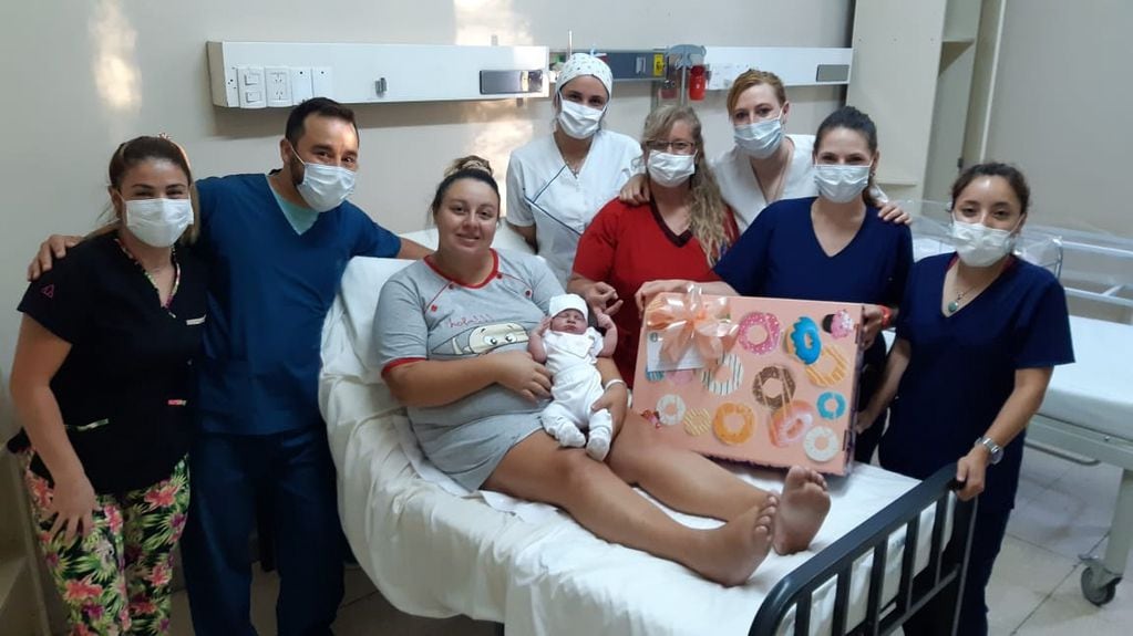 Juana Ortiz en brazos de su mamá Camila Cameruccio junto al equipo médico que ayudó en el parto e integrantes de la Cooperadora del Hospital Schestakow. Gentileza