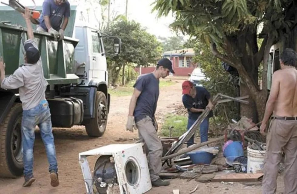 Trabajadores municipales de Posadas, limpiando las zonas afectadas para impedir la proliferación del dengue.