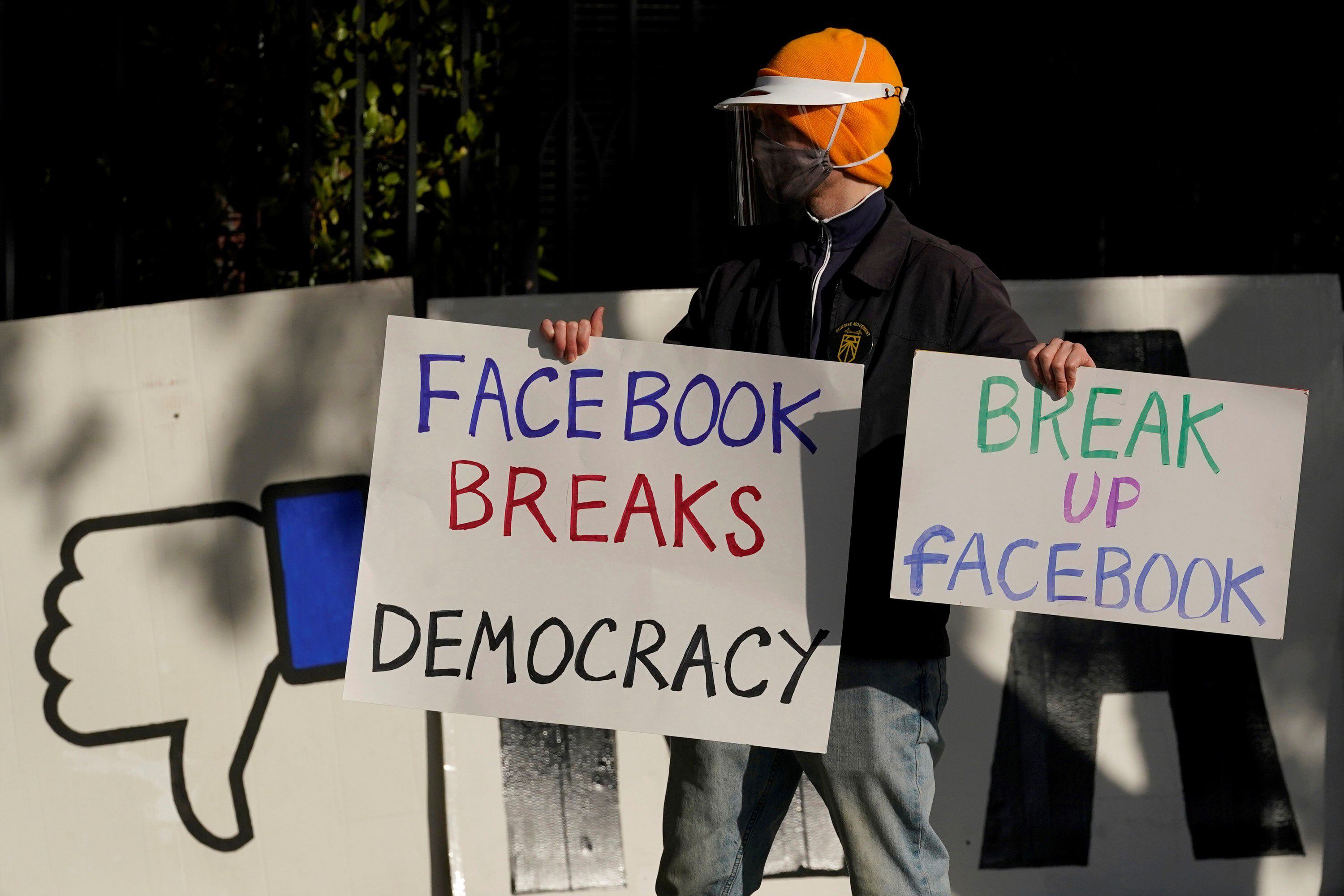 un manifestante se une a otros fuera de la casa del CEO de Facebook, Mark Zuckerberg, para protestar por lo que dicen que Facebook difunde desinformación en San Francisco.