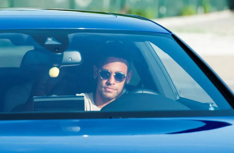 TOPSHOT - Barcelona's Brazilian forward Neymar drives into the parkinglot to takes part in a training session at the Sports Center FC Barcelona Joan Gamper in Sant Joan Despi, near Barcelona on August 2, 2017 following rumour that Neymar is considering a move to French club PSG for which the club would have to shell out some 222 million euros, enough to trigger the 25-year-old's transfer release clause. / AFP PHOTO / Josep LAGO