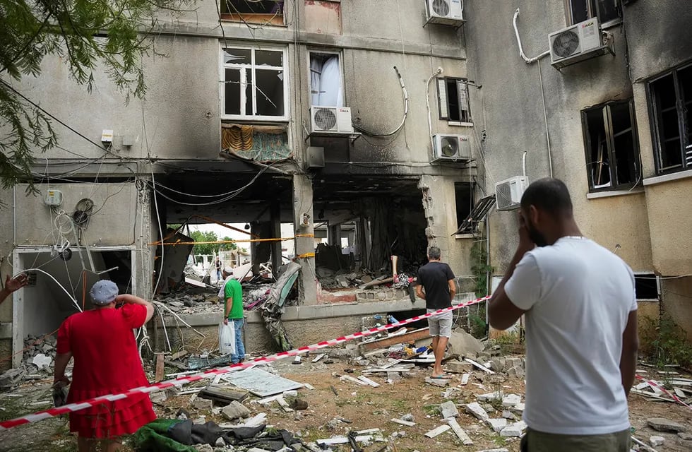 Israelíes inspeccionan un edificio residencial tras ser alcanzado por un cohete (AP)