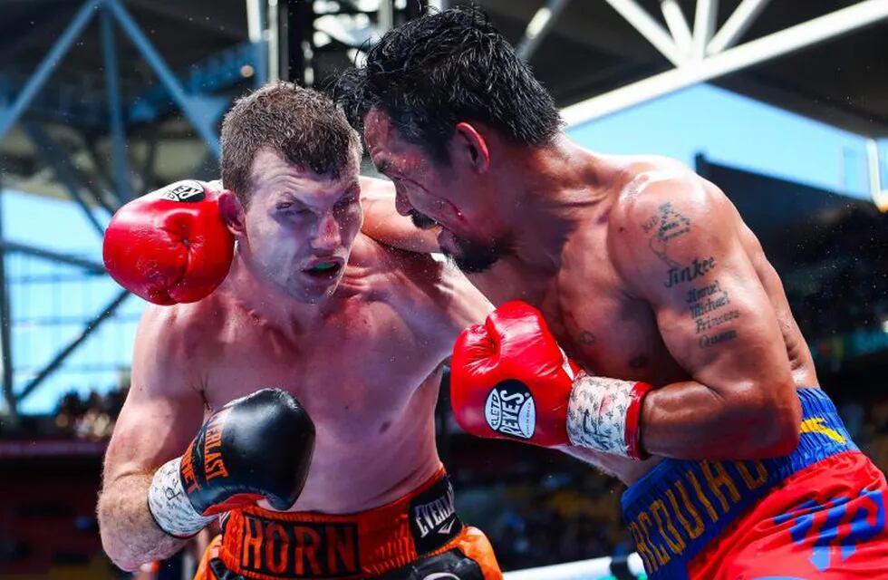 TOPSHOT - CORRECTION - Manny Pacquiao (R) of the Philippines fight Jeff Horn (L) of Australia during the World Boxing Organization boat at Suncorp Stadium in Brisbane on July 2, 2017.  / AFP PHOTO / Patrick HAMILTON / -- IMAGE RESTRICTED TO EDITORIAL USE - STRICTLY NO COMMERCIAL USE -- / “The erroneous mention[s] appearing in the metadata of this photo by Patrick HAMILTON has been modified in AFP systems in the following manner: [July 2] instead of [July 1]. Please immediately remove the erroneous mention[s] from all your online services and delete it (them) from your servers. If you have been authorized by AFP to distribute it (them) to third parties, please ensure that the same actions are carried out by them. Failure to promptly comply with these instructions will entail liability on your part for any continued or post notification usage. Therefore we thank you very much for all your attention and prompt action. We are sorry for the inconvenience this notification may cause and rema