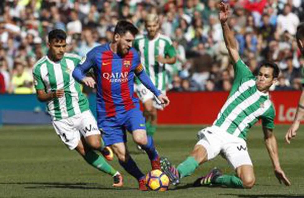 GRA102. SEVILLA, 29/01/2017.- El delantero argentino del FC Barcelona, Lionel Messi, se lleva la pelota ante Matías Nahuel (i) y Aissa Mandi (d), del Real Betis, durante el partido de Liga de Primera División frente al Real Betis correspondiente a la jornada 20 que juegan hoy en el estadio Benito Villamarín de Sevilla. EFE/Julio Muu00f1oz