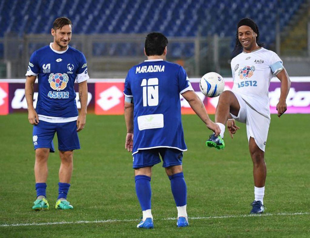 Diego Armando Maradona, junto al jugador italiano del AS Roma Francesco Totti y al jugador brasileño Ronaldinho en 2016 (EFE)