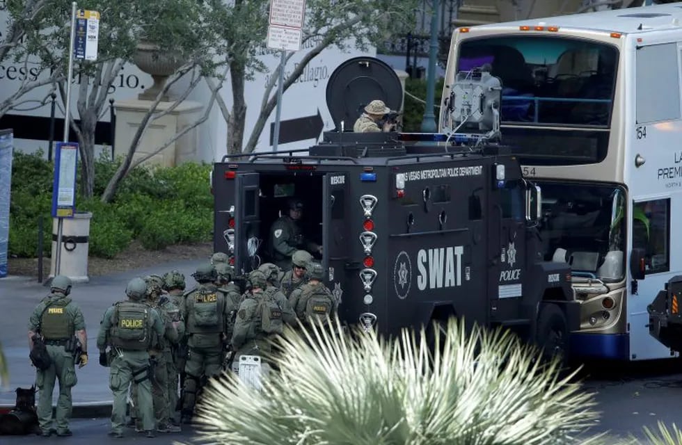 Las Vegas SWAT officers surround a bus along Las Vegas Boulevard, Saturday, March 25, 2017, in Las Vegas. Police say part of the Strip has been closed down after a shooting. (AP Photo/John Locher)