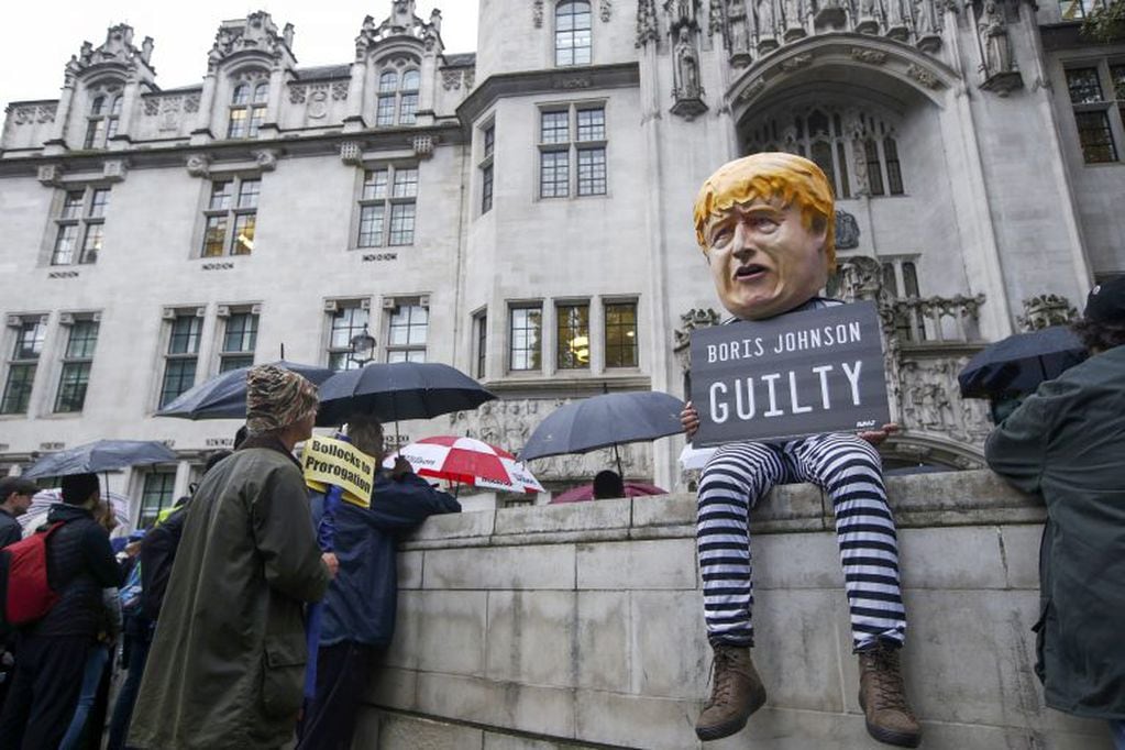 Un manifestante, con una máscara que representa al primer ministro del Reino Unido, Boris Johnson, sostiene un cartel que dice "Boris Johnson Culpable" frente a la Corte Suprema en Londres, Reino Unido, el martes 24 de septiembre de 2019. Crédito: Luke MacGregor/Bloomberg.