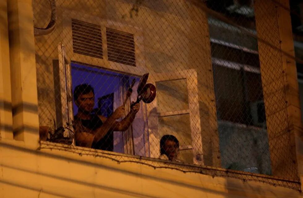 A man bangs a pot at the window of his house as he protests against Brazilian President Jair Bolsonaro during the coronavirus disease (COVID-19) outbreak in Rio de Janeiro, Brazil, March 18, 2020. REUTERS/Ricardo Moraes