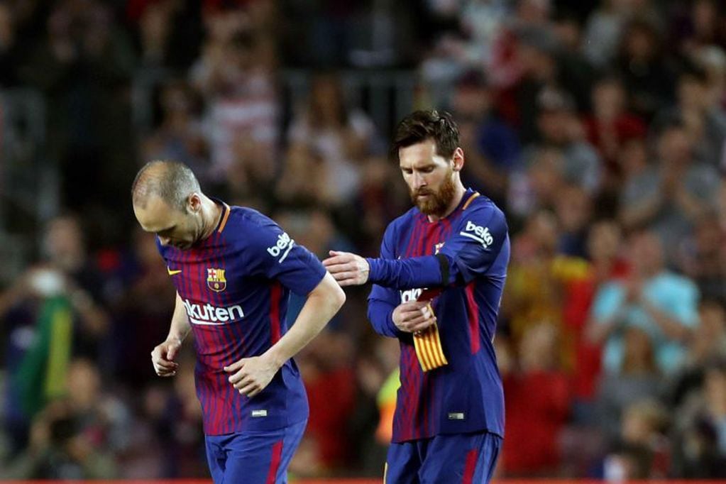 Andrés Iniesta le entrega la cinta de capitán a Lionel Messi. Foto: EFE.
