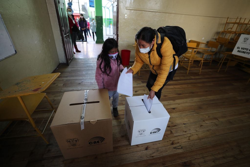 Una niña acompaña a una mujer a votar en un centro electoral en Quito (Ecuador). (Foto: EFE/ José Jácome)