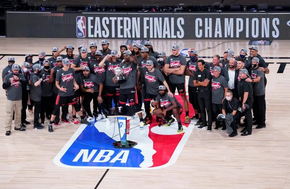 The Miami Heat celebrate their NBA conference final playoff basketball game win over the Boston Celtics with the Eastern Final trophy Sunday, Sept. 27, 2020, in Lake Buena Vista, Fla. (AP Photo/Mark J. Terrill)