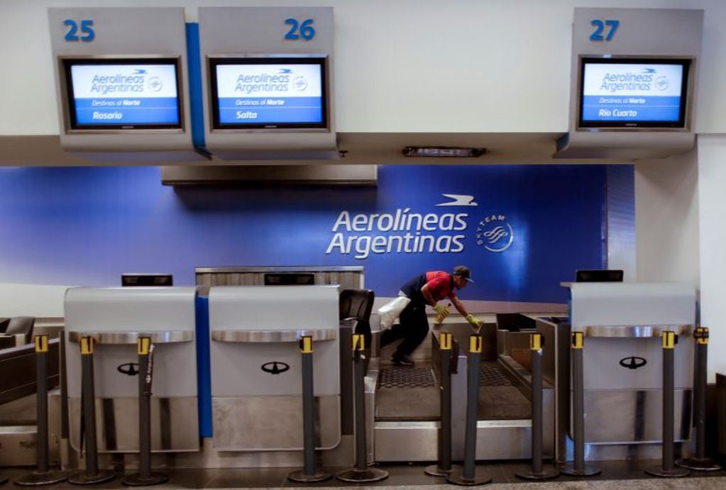 A worker cleans the Aerolineas Argentinas check-in stand at the airport in Buenos Aires, Argentina, Tuesday, Oct. 31, 2017. A 24-hour strike by workers of the state-run companies, Aerolineas Argentinas and Austral, is causing the cancellation of dozens of flights, grounding of thousands of passengers. (AP Photo/Natacha Pisarenko buenos aires  paro de trabajadores de aerolineas argentinas y austral medida de fuerza de los gremios aeronauticos pasajeros varados esperando poder viajar