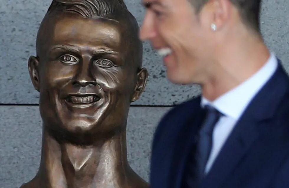 Real Madrid's Cristiano Ronaldo stands next to a bust of himself at the Madeira international airport outside Funchal, the capital of Madeira island, Portugal, Wednesday March 29, 2017. Madeira International Airport has been renamed after local soccer sta