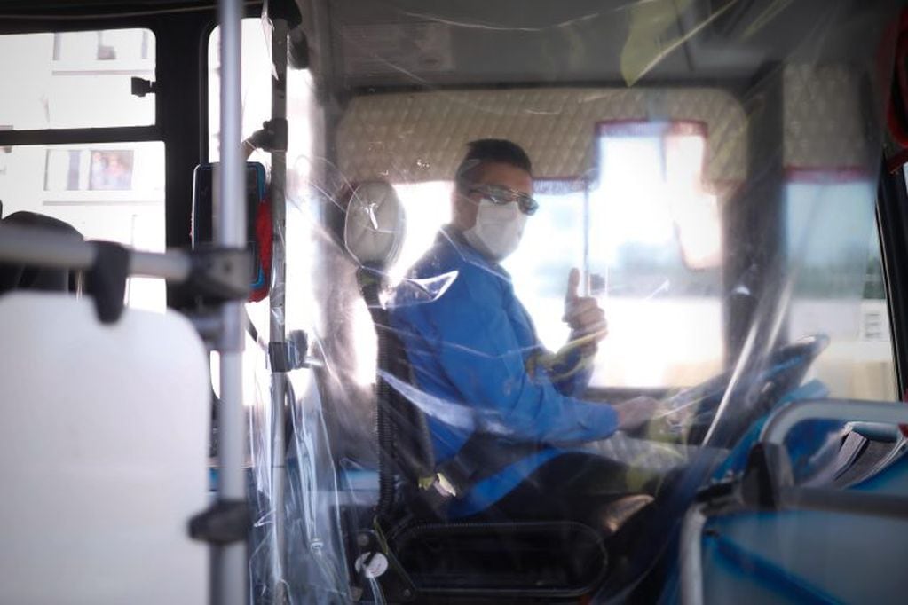 Un conductor de bus del transporte público utiliza tapabocas como medida de protección contra el Covid-19 (EFE/ Juan Ignacio Roncoroni)