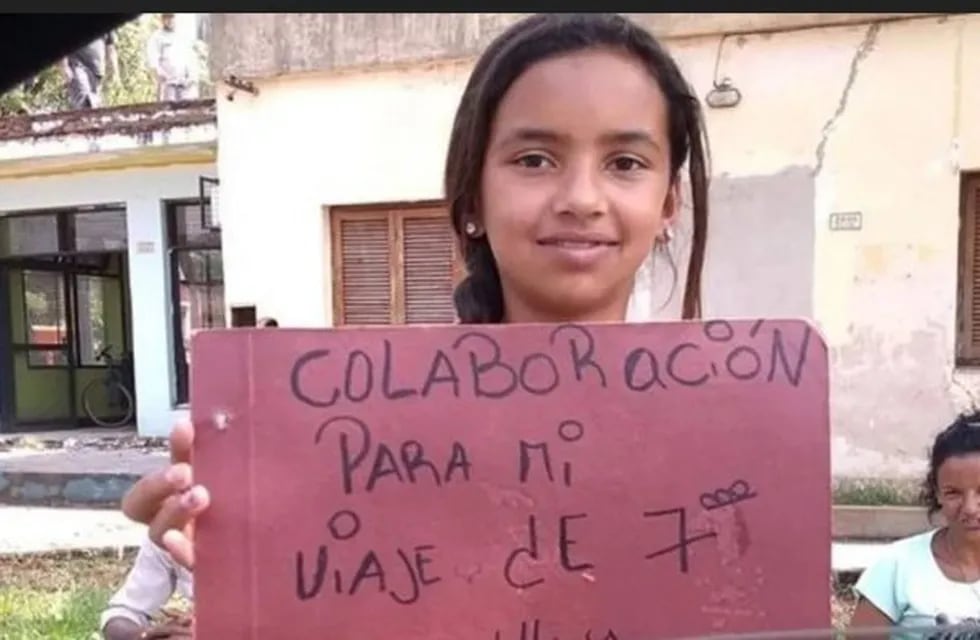 Daiana y su cartel en el que pide ayuda para su viaje de estudios que paga vendiendo limones en la calle. (Clarín)