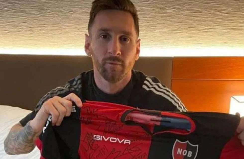 Lionel Messi con la camiseta de Newell's firmada por el plantel
