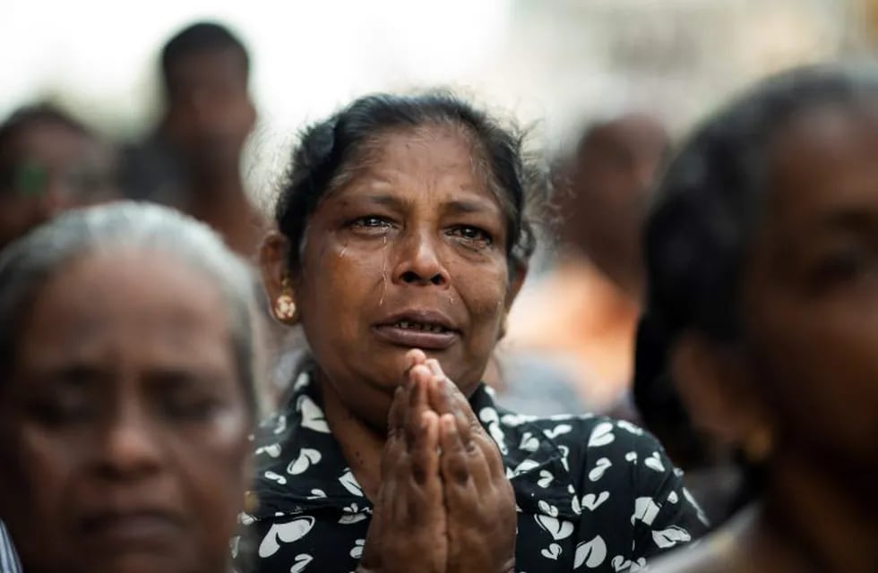 TOPSHOT - A devotee cries as she prays at a barricade near St. Anthony's Shrine in Colombo on April 28, 2019, a week after a series of bomb blasts targeting churches and luxury hotels on Easter Sunday in Sri Lanka. - Sri Lanka's Roman Catholic leader on April 28 condemned the Easter attacks as \