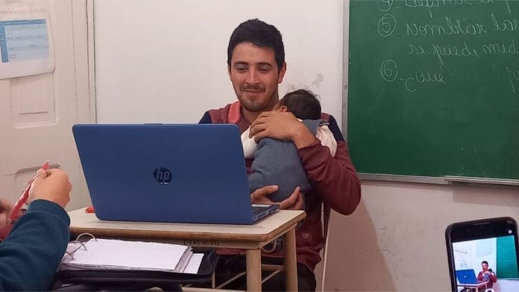 Docente da clases con un bebe en brazos en escuela de Entre Ríos