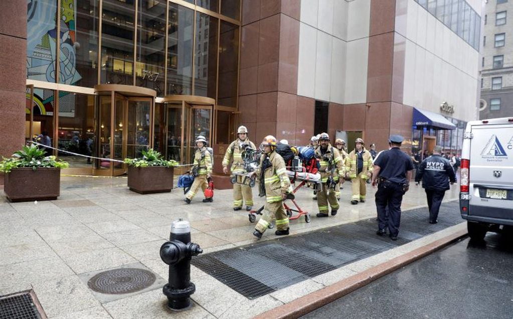 Bomberos llegan al edificio con el que un helicóptero se estrelló, este lunes, en el centro de Manhattan, Nueva York, (EE.UU.). EFE/ Jason Szenes