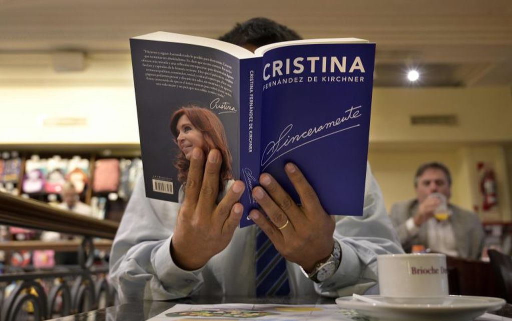A man holds a copy of Argentina's former president and current senator Cristina Fernandez de Kircher's book "Sinceramente" (Sincerely) at a cafe in downtown Buenos Aires on April 25, 2019. - The book is for sale in Argentine stores since Thursday, six months ahead of October's general elections. Kirchner, 66, is being investigated in corruption cases. (Photo by JUAN MABROMATA / AFP)