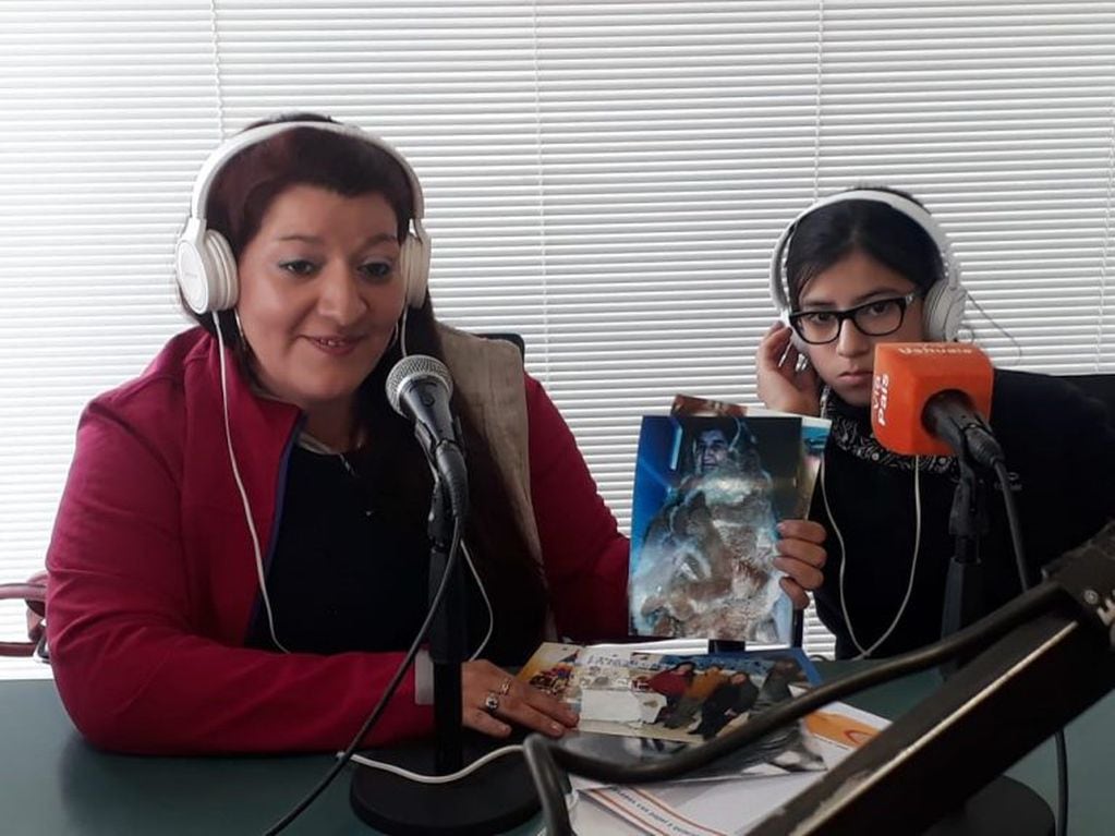 Vanina Ojeda Maldonado en estudios de Vía Ushuaia Radio mostrando documentos fotográficos de su ancestros