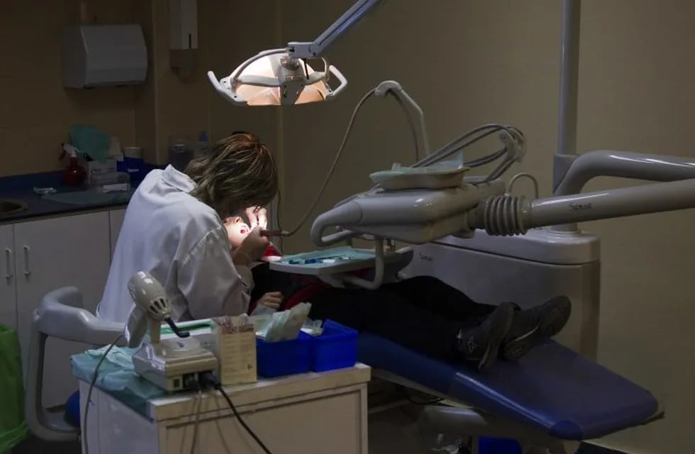 A dentist works on a patient at a public health clinic in Madrid March 27, 2012. Spain will announce some of its deepest budget cuts ever on Friday, though evaporating growth prospects mean it is likely to fall short of what is needed to meet strict public deficit targets. Picture taken March 27, 2012. REUTERS/Sergio Perez  (SPAIN - Tags: HEALTH BUSINESS POLITICS) españa madrid  españa consultorio odontologico dentista dentistas