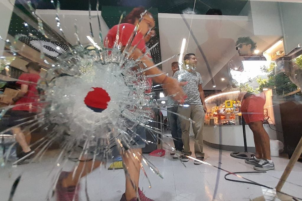 Los impactos en el vidrio del supermercado de la familia Roccuzzo, que traspasaron la persiana. Foto: Gentileza Clarín.