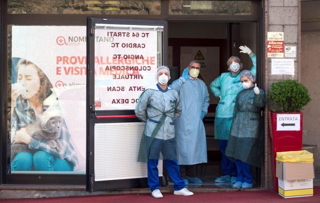 Médicos y enfrermeros saludan a la entrada de una clínica durante el estado de emergencia por el coronavirus en Roma, Italia (Foto: EFE/Maurizio Brambatti)
