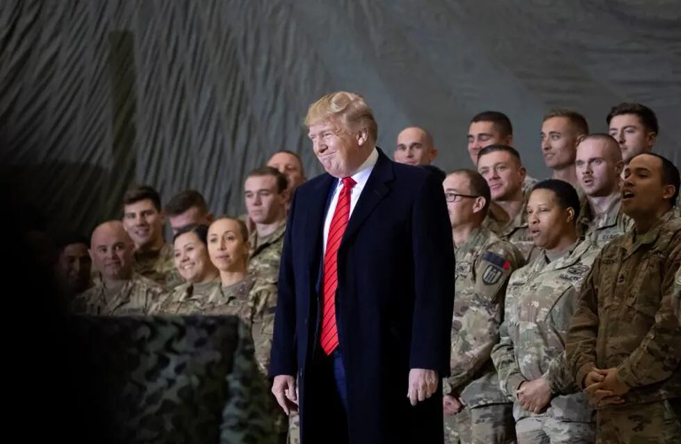 FILE - In this Nov. 28, 2019, file photo President Donald Trump smiles before addressing members of the military during a surprise Thanksgiving Day visit at Bagram Air Field, Afghanistan. Trump has held himself up as a champion of U.S. troops without rival. Now, with his presidency on the line, he’s casting suspicion on a tool of participatory democracy, the mail-in ballot, that has allowed U.S. military personnel to participate in elections while serving far from home since the War of 1812. (AP Photo/Alex Brandon, File)