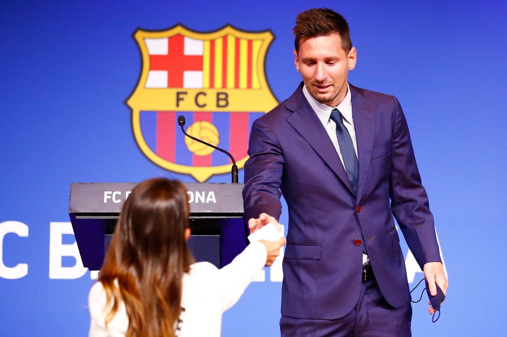 Antonela Roccuzzo le da un pañuelo a Lionel Messi en la conferencia de prensa del Barcelona.