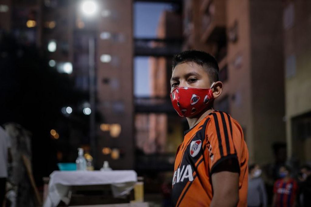 Un niño de Fuerte Apache, en el partido Tres de Febrero, usa un tapaboca con el escudo de River Plate. (Juan Ignacio Roncoroni/EFE)
