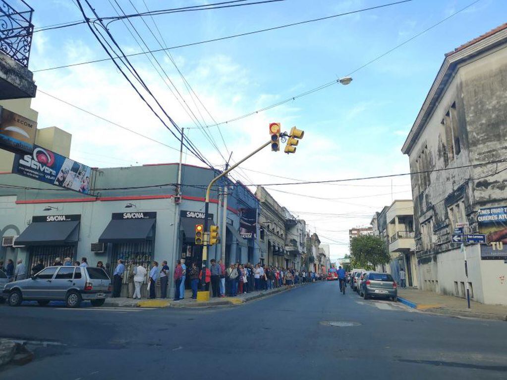 Largas colas en la esquina de Pellegrini y San Lorenzo por los usuarios que esperan para ser atendidos. (Foto: Natalia Pernizza).
