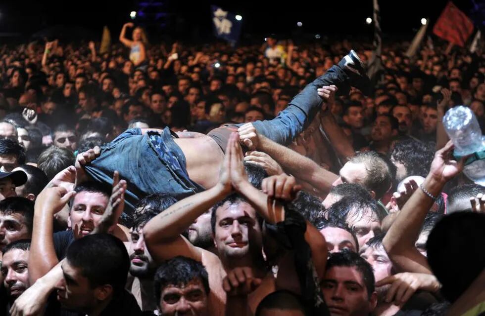 A fan who was dancing in the mosh pit is lifted to remove him from the area, toward security, during Argentine singer Indio Solari's show in Olavarria, Argentina, Saturday, March 11, 2017. Officials say two people died in a crush during Solari's massive rock concert. (AP Photo/Hernan Leonardi)