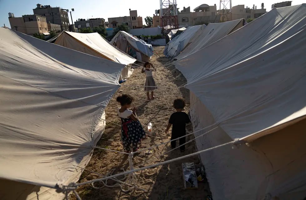 Niños palestinos desplazados por los bombardeos israelíes sobre Gaza caminan entre tiendas proporcionadas por la ONU en un campamento levantado en Khan Younis, el 19 de octubre de 2023.