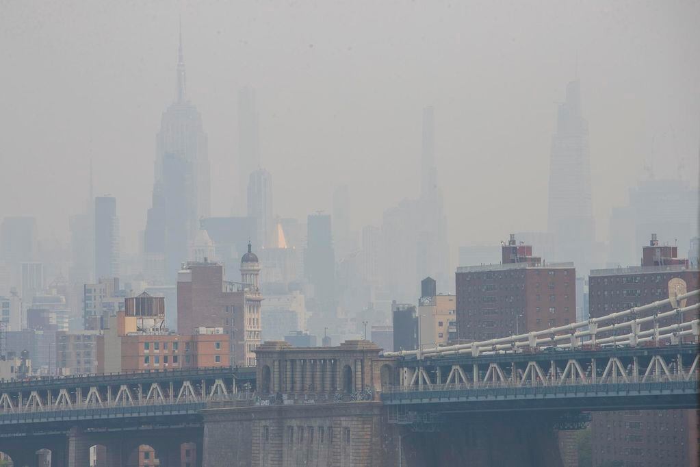 El humo como resultado de los incendios forestales canadienses envuelve el horizonte de la ciudad de Nueva York, convirtiéndolo en la peor calidad del aire en el mundo en este momento, visto desde el puente de Brooklyn en Nueva York. Foto: EFE/EPA/SARAH YENESEL