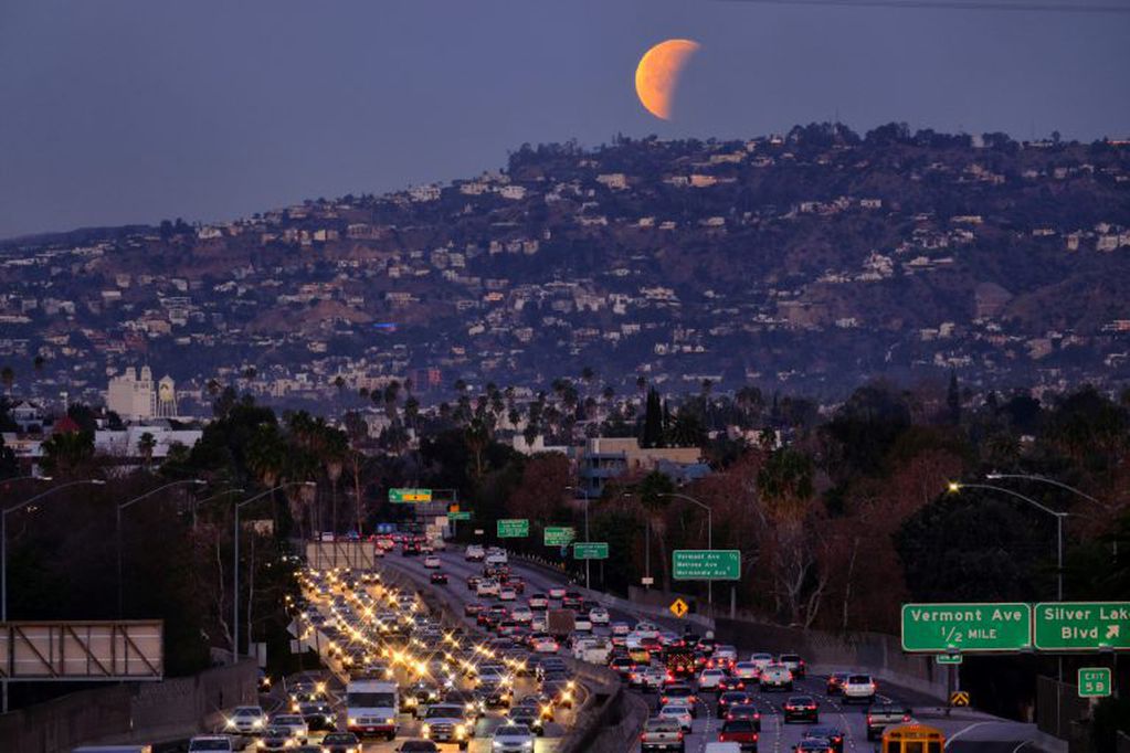 A super blue blood moon is seen setting behind the Hollywood hills in Los Angeles on Wednesday Jan. 31, 2018. The moon is putting on a rare cosmic show. It's the first time in 35 years a blue moon has synced up with a supermoon and a total lunar eclipse. NASA is calling it a lunar trifecta: the first super blue blood moon since 1982. That combination won't happen again until 2037. (AP Photo/Richard Vogel)